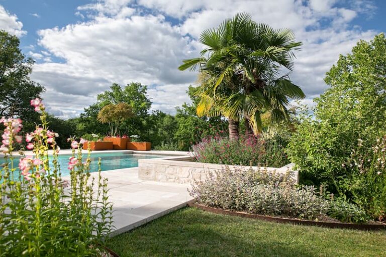Aménagement floral et arboré autour d'une piscine réalisé par Serra Paysage