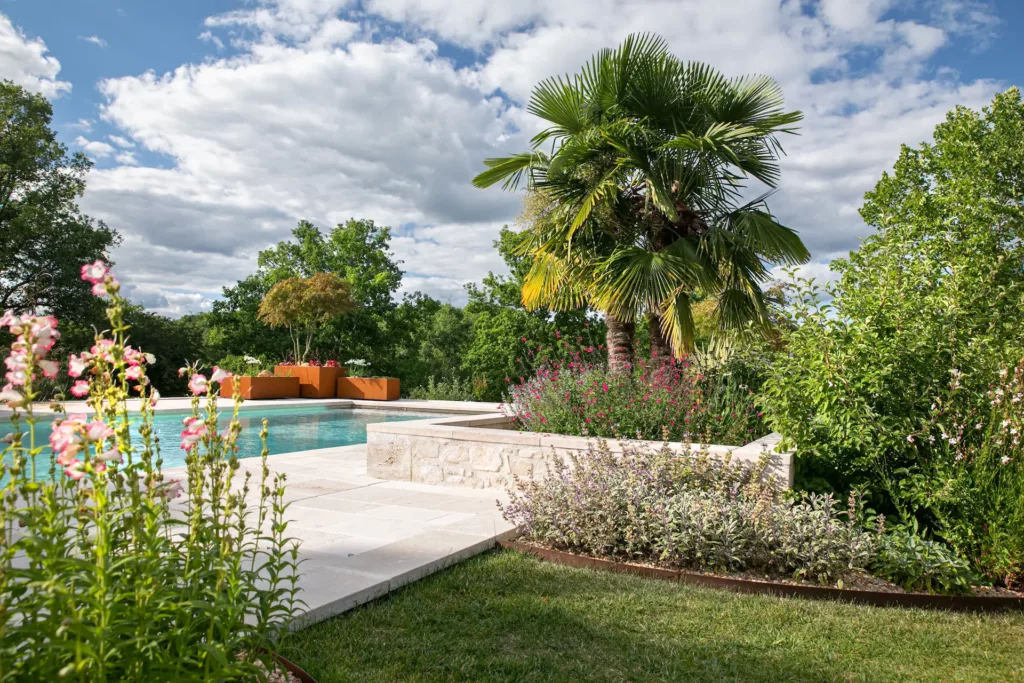 Paysage Dordogne, habillage d'une piscine avec un espace floral et arboré réalisé par Serra Paysage